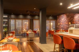 a restaurant with tables and chairs and a bar at La Mansion Vi Vadi Hotel in Munich
