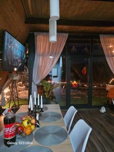 a dining room with a table and a television at Cabana Apuseni Forest 