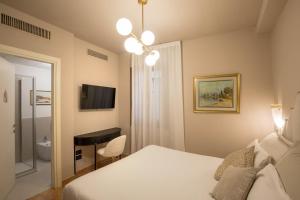 a bedroom with a bed and a desk and a television at Daplace - Antica Casa Coppo in Venice