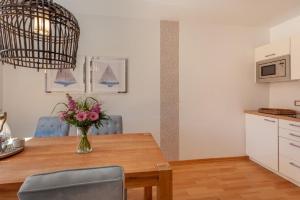 a dining room table with a vase of flowers on it at Birdie mit Ostseeblick Haus Fore in Lohme