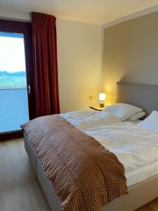 a bedroom with a large bed with a large window at Birdie mit Ostseeblick Haus Fore in Lohme +2 photos