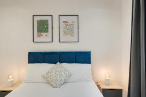 een slaapkamer met een bed met drie foto's aan de muur bij 2 Bedroom Aprtmnt For Upto 6 Nr Centre, Uni &Parks in Cardiff