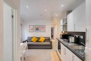 een keuken en een woonkamer met een bank in een kamer bij 2 Bedroom Aprtmnt For Upto 6 Nr Centre, Uni &Parks in Cardiff