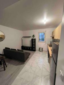 a living room with a couch and a kitchen at Appartement Dammarie-les-Lys in Dammarie-lès-Lys