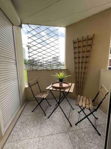 a small table and two chairs on a balcony at Appartement Dammarie-les-Lys in Dammarie-lès-Lys