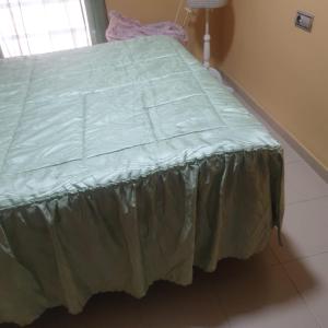 a bed with a green comforter in a room at El MIRADOR DE LA PLAYA in Melilla