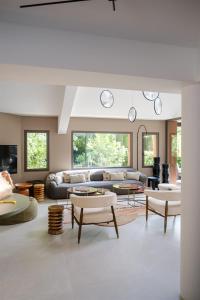 a living room with couches and tables at Le Répertoire - La Villa des 2 Soeurs in Pernes-les-Fontaines