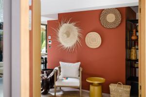 Zimmer mit einem Stuhl und Hüten an der Wand in der Unterkunft Le Répertoire - La Villa des 2 Soeurs in Pernes-les-Fontaines