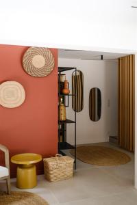 ein Wohnzimmer mit orangefarbenen Wänden und einem Spiegel in der Unterkunft Le Répertoire - La Villa des 2 Soeurs in Pernes-les-Fontaines