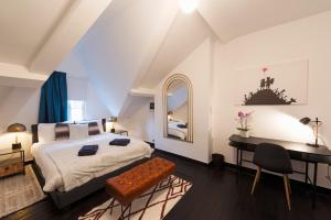 um quarto com uma cama, uma secretária e uma mesa em Fish Market Apartments em Bruxelas