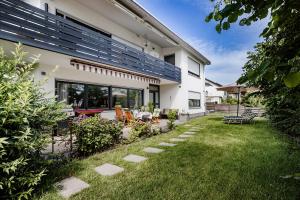 einen Hinterhof eines Hauses mit Terrasse und Gras in der Unterkunft Ferienwohnung Wäller Sonnenschein in Westerburg