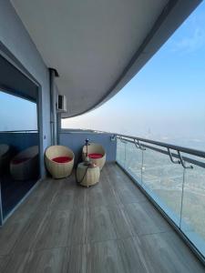 a room with two chairs and a balcony with a view at The Sky Stay (By Vrs) in New Delhi