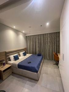 a bedroom with a large bed with a blue blanket at The Sky Stay (By Vrs) in New Delhi