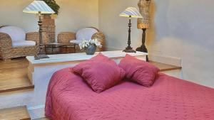 1 dormitorio con 1 cama con 2 almohadas moradas en Domaine Les Terres de Saint-Hilaire, en Ollières