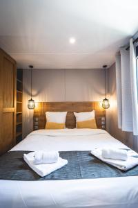 ein Schlafzimmer mit einem großen weißen Bett mit Handtüchern darauf in der Unterkunft Les Prairies de la Mer in Grimaud