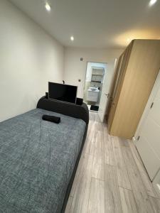 a bedroom with a bed and a television in it at Modern 1BD Flat in London