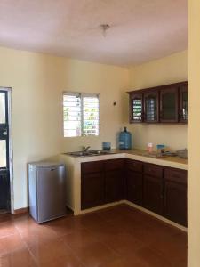 a kitchen with wooden cabinets and a stainless steel refrigerator at Típica casa dominicana in Las Galeras