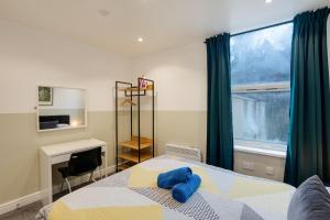 a bedroom with a bed with a blue towel on it at Duplex Apartment For Up to 13 Near City Centre in Cardiff