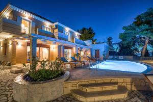 a house with a swimming pool in front of a house at Castelli Villa in Lagópodhon