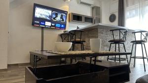 un soggiorno con tavolo e TV a parete di Appartement Maenat a Borgo