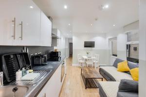 een keuken en een woonkamer met een bank en een tafel bij 2 Bedroom Apartment for up to 6 Nr Centre in Cardiff