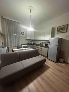 a living room with a couch in front of a kitchen at Mirella Apt, 2Min Train Station in Mestre
