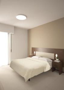 a bedroom with a large bed and a large window at Helios Beach Hotel in Milano Marittima
