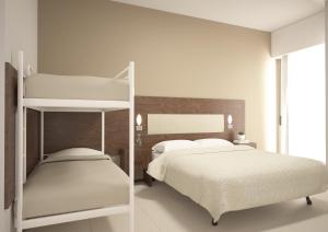 1 dormitorio con 2 camas y 1 litera en Helios Beach Hotel, en Milano Marittima