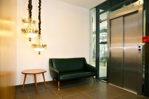 une chaise verte et une table dans le couloir dans l'établissement Moderna, à Coimbra