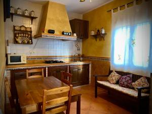 una cocina con una mesa de madera y un sofá. en Casa LAS TABLAS DEL BULLAQUE, en Porzuna