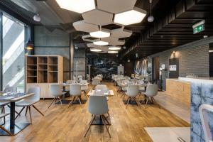 a restaurant with tables and chairs in a room at Sky Loft Hotel Kyiv by Rixwell International in Kyiv