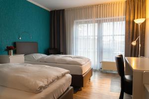 a hotel room with two beds and a window at Vareler Brauhaus-Hotel Varel Dangast in Varel