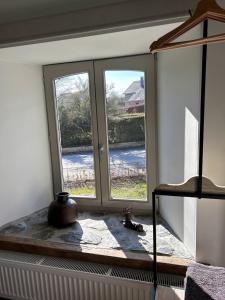 Pokój z dwoma oknami i wazą na parapecie w obiekcie B&B Le Nid d'Hirondelle w mieście Houffalize
