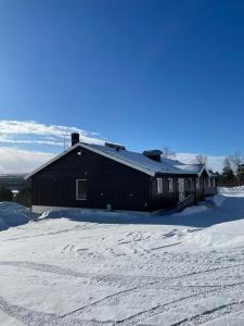 a black building with snow on the ground in front at SamiCity Hotel As in Karasjok
