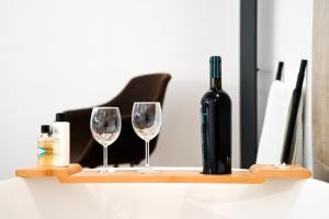 a bottle of wine and two glasses on a shelf at Suitehome B&B con vasca in Troia
