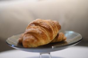 a plate with a croissant on top at Suitehome B&B con vasca in Troia