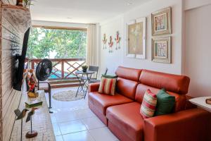 uma sala de estar com um sofá vermelho e uma varanda em Porto Praia do Forte na Praia do Forte