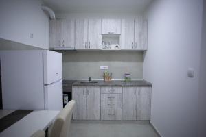 cocina con armarios de madera y nevera blanca en Stan na dan Ub en Ub