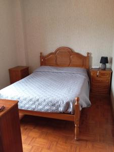 um quarto com uma cama de madeira e uma cómoda de madeira em LOFT Aver-o-mar 2 min a pé da praia na Póvoa do Varzim