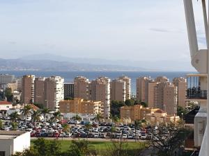 a city with cars parked in a parking lot at Apartamento Vistas al mar in Torremolinos