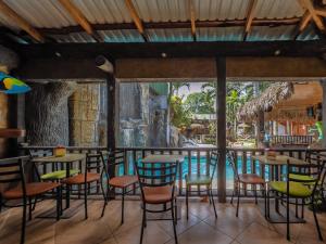 a bar with chairs and tables in front of a pool at Poshtel Arenal in Fortuna