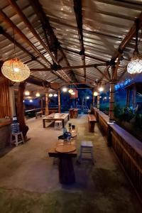 a large room with tables and ping pong tables at Lumbung Langit Bali house & hostel in Tampaksiring