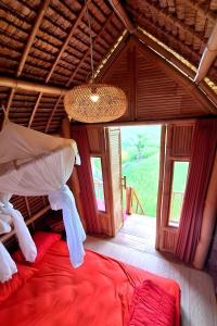 a bedroom with a bed in a room with a window at Lumbung Langit Bali house & hostel in Tampaksiring