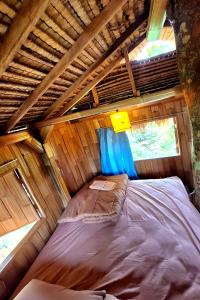 ein Bett in der Mitte eines Zimmers in einem winzigen Haus in der Unterkunft Lumbung Langit Bali house & hostel in Tampaksiring