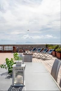 einen Balkon mit Stühlen, einem Tisch und Meerblick in der Unterkunft Maybritt's Home, rooftop in front of the castle! in Neapel