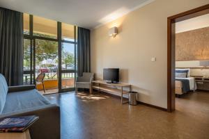 a living room with a couch and a television at VILA PARK Nature & Business Hotel in Santo André