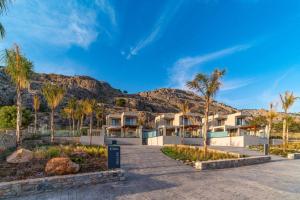 un complejo con palmeras y montañas en Villa Ouranos, en Kiotari