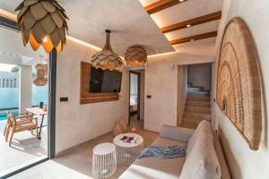 Una sala de estar con un sofá, un televisor y una mesa. en Villa Ouranos, en Kiotari