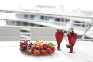 une assiette de fruits sur une table avec deux verres à vin dans l'établissement INFINITY VIEW 8, à Arenales del Sol