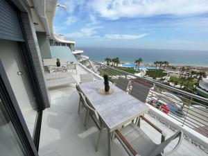 un balcon avec une table et des chaises et l'océan dans l'établissement INFINITY VIEW 8, à Arenales del Sol